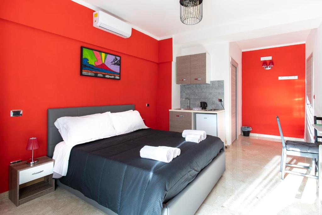 a bedroom with red walls and a bed with towels on it at Borgo Santa Lucia B&B in Naples