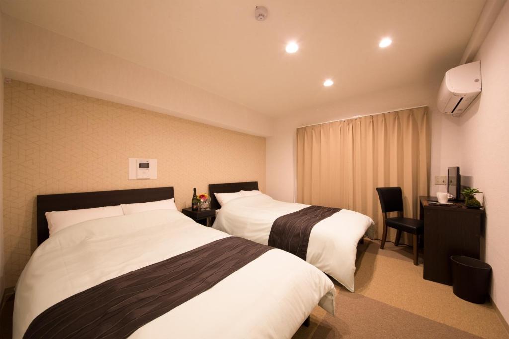 a hotel room with two beds and a desk at Osaka - Hotel / Vacation STAY 65266 in Osaka