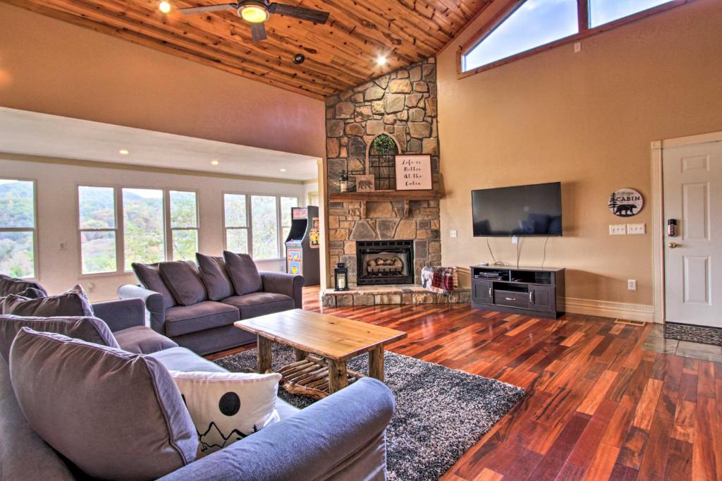 uma sala de estar com sofás e uma lareira em Luxe Cabin with Covered Pool and Smoky Mountain Vistas em Sevierville