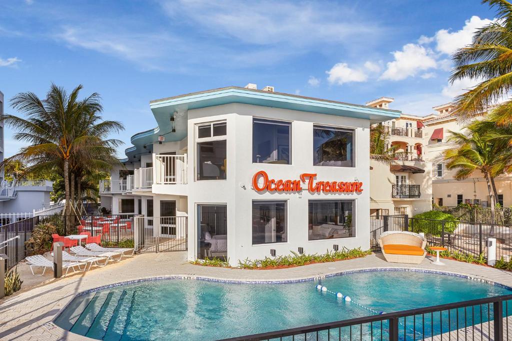 budynek z basenem przed budynkiem w obiekcie Ocean Treasure Beachside Suites w mieście Fort Lauderdale