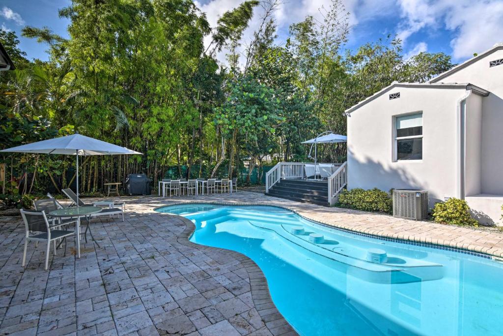 a swimming pool with a table and chairs next to a house at Modern Miami Villa with Pool Oasis about 5 Mi to Beach! in Biscayne Park