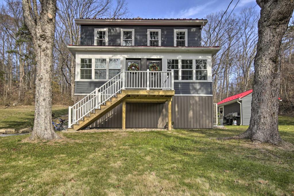 uma grande casa com um alpendre e um deque em Quiet Escape with Hot Tub, 5 Miles to Raystown Lake! em Entriken