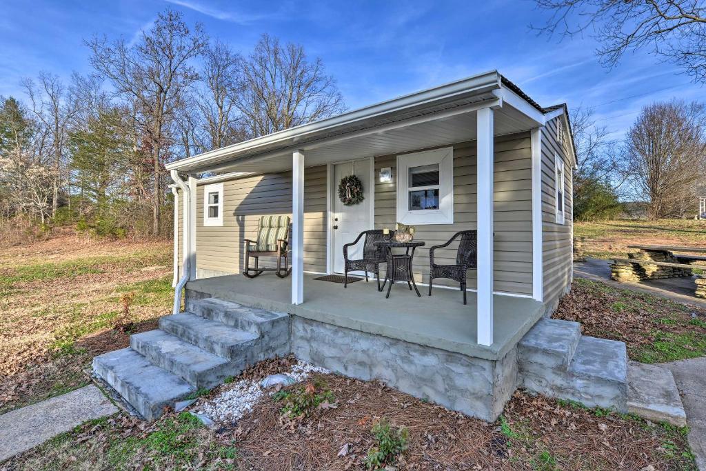 ein kleines Haus mit einer Veranda mit Tisch und Stühlen in der Unterkunft Six Waterpots Cottage II in Blue Ridge Mountains in Lenoir