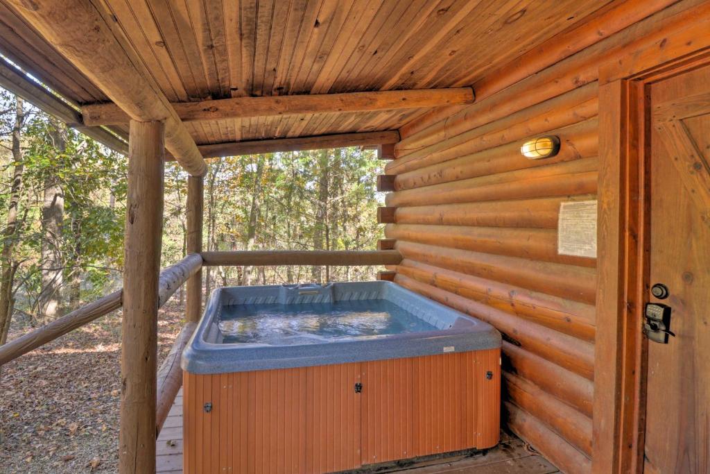 a hot tub sitting inside of a wooden cabin at Peaceful Cabin 4 Mi to Broken Bow Lake with Hot Tub! in Stephens Gap