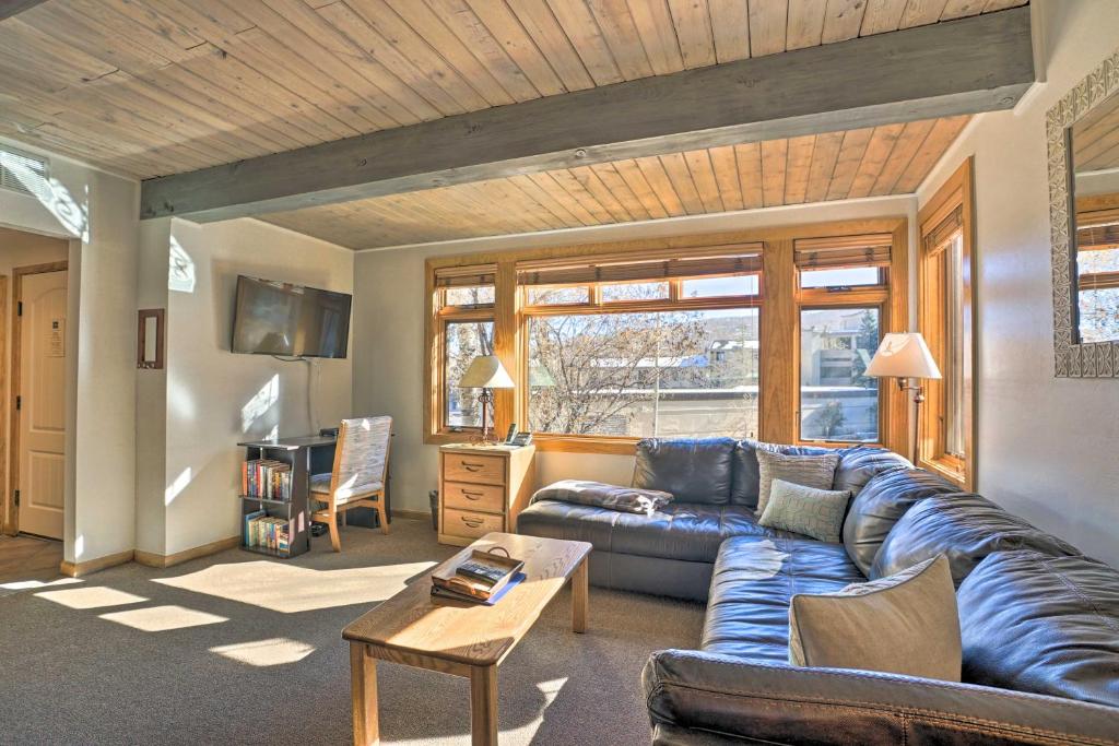 a living room with a blue couch and a table at Ski Lovers Studio with Easy Pool and Hot Tub Access! in Snowmass Village