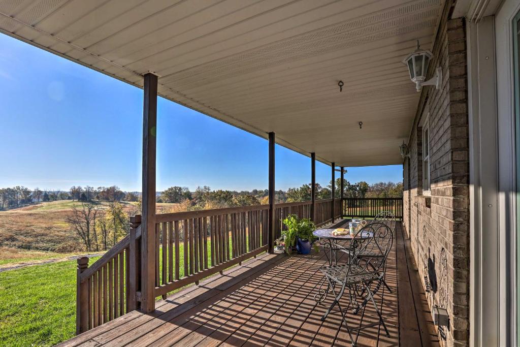 a deck with a table and chairs on a house at Family Farmhouse on 160-Acre Ranch with Hiking Trail in Lawrenceburg