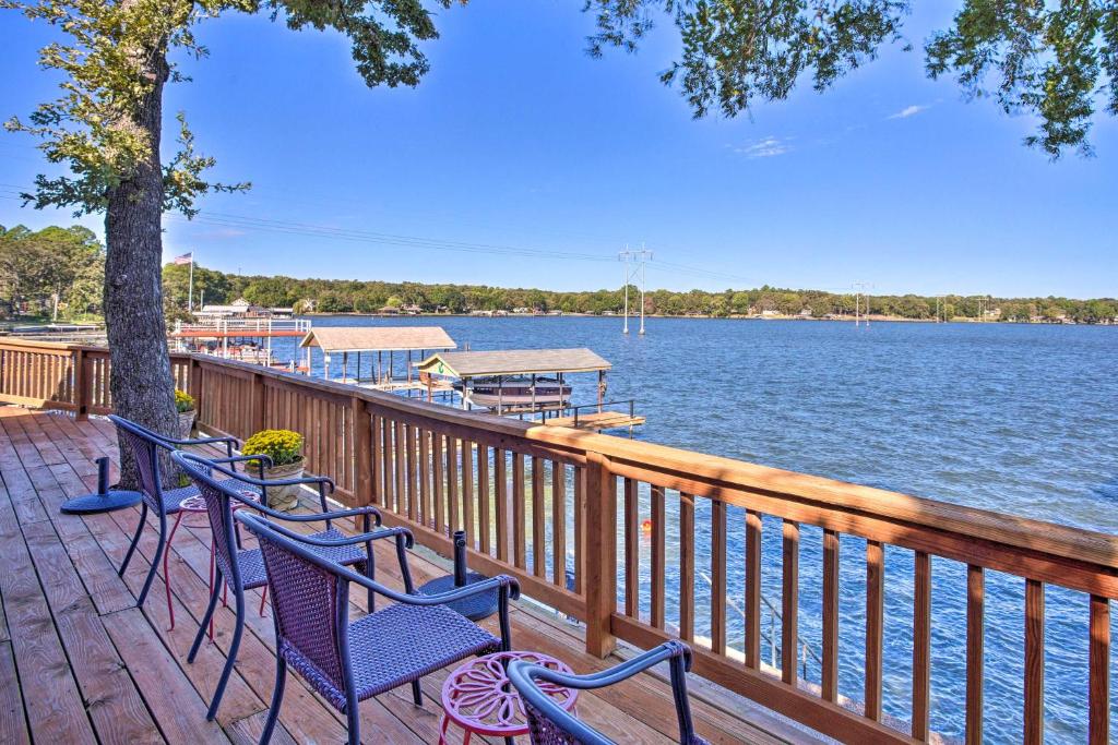 a row of chairs on a deck next to the water at Waterfront Home in Tool with Dock, Fire Pit and Patio! in Tool