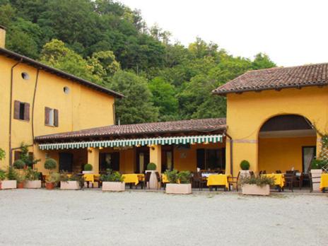 a yellow building with tables and chairs in a courtyard at Agriturismo Ca Noale in Teolo