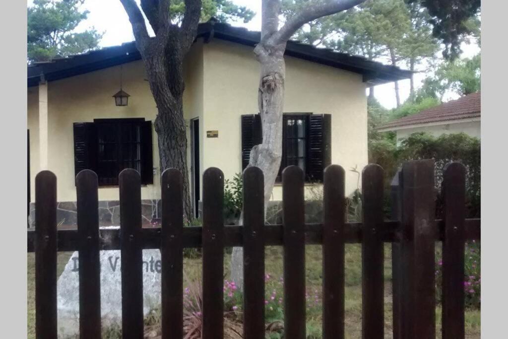una valla de madera frente a una casa en Chalet Don Vicente en Villa Gesell