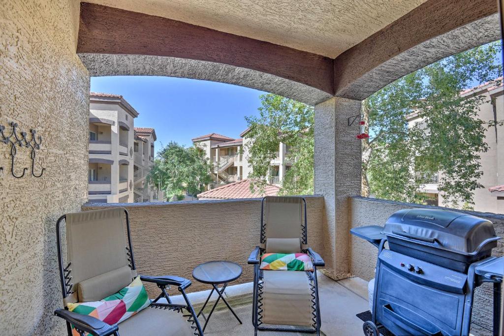 a patio with two chairs and a table and a grill at Mesa Condo with Private Patio and Grill Pool Access! in Mesa