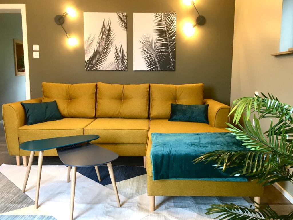 un soggiorno con divano giallo e 2 dipinti di Four a Coblenza