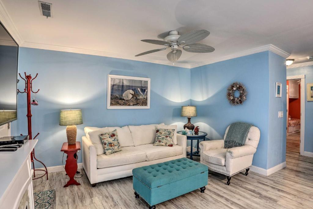 sala de estar con paredes azules, sofá y sillas en Breezy Murrells Inlet Condo with Deck Walk to Beach, en Myrtle Beach