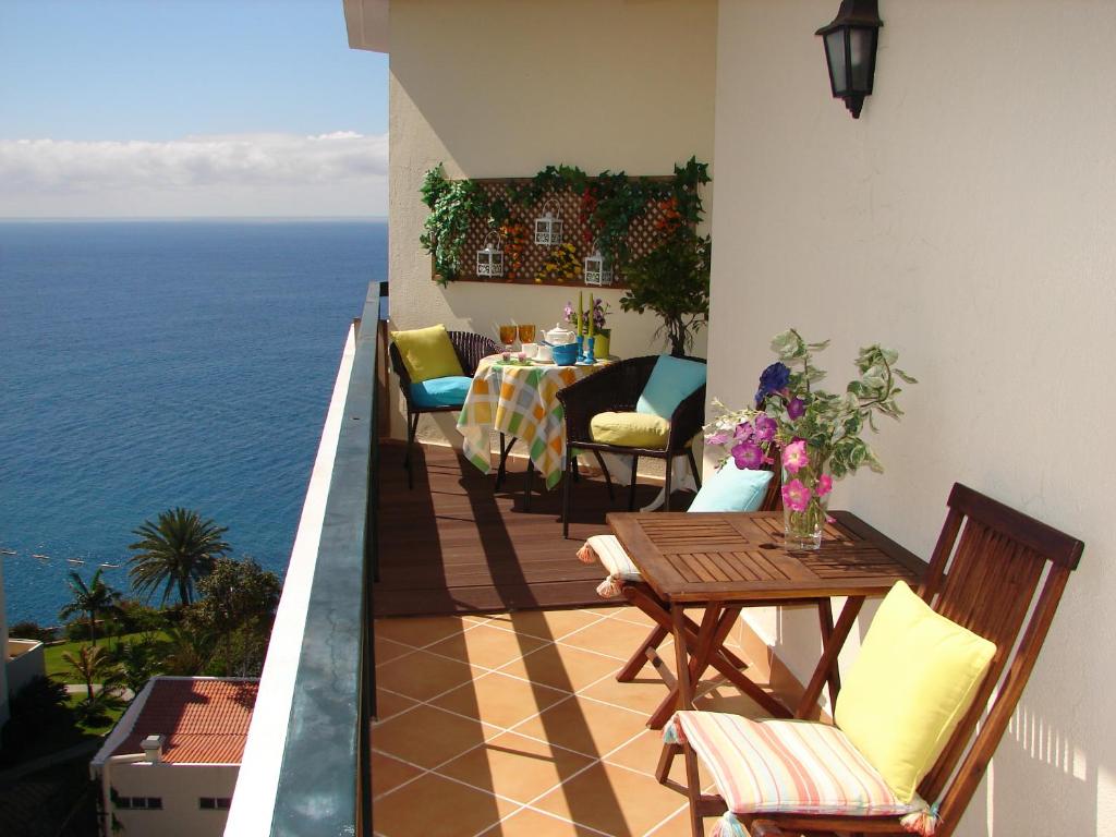 een balkon met een tafel en stoelen en de oceaan bij Bright Studio in Funchal