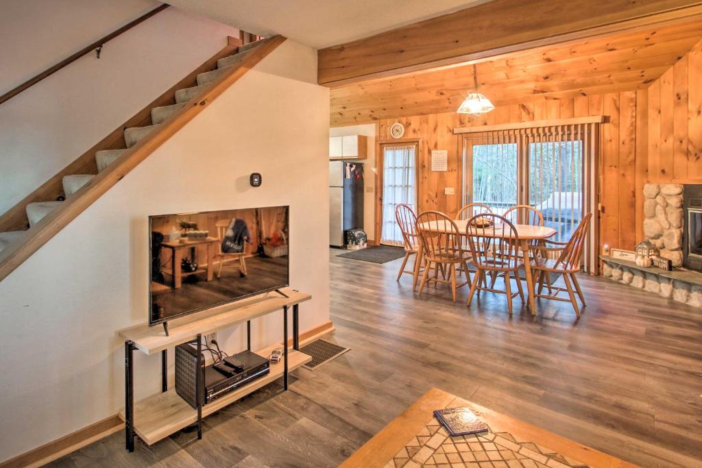 sala de estar de planta abierta con chimenea y comedor en Lakeview Forest Cabin with Deck Less Than half Mile to Beach!, en Madison