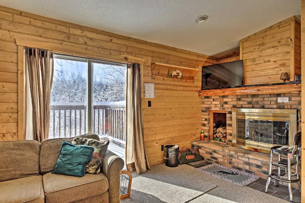 uma sala de estar com um sofá e uma lareira em Black River Retreat 3 Mi to Powderhorn Mountain! em Ironwood