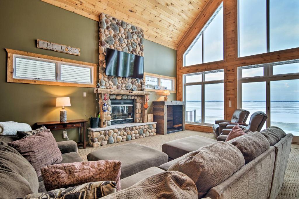 sala de estar con sofá y chimenea en Family-Friendly Lake Mitchell Oasis Hike and Ski! en Cadillac