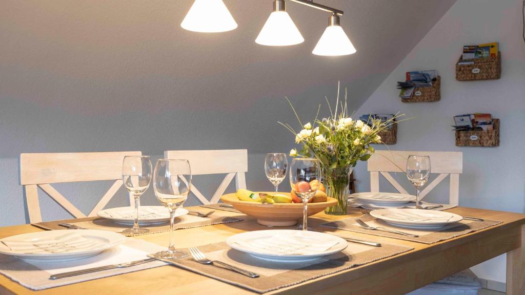 a table with plates and glasses and a bowl of fruit at Weissenstein in Bremerhaven