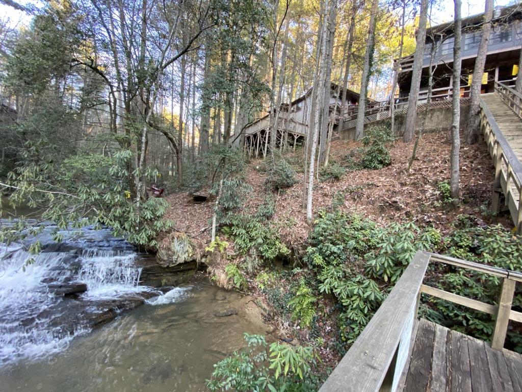 un pont sur une rivière avec une cascade dans l'établissement Cascades Inn, à Tiger