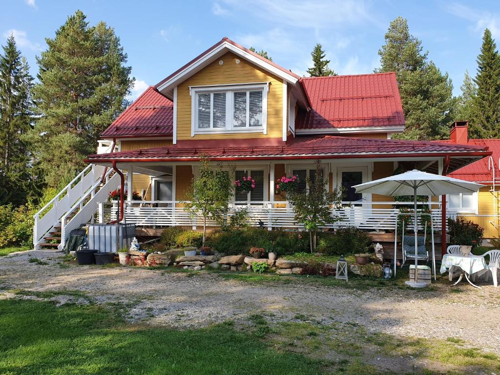 una casa con techo rojo y sombrilla en TOIVONNIEMEN KOTIMAJOITUS, 