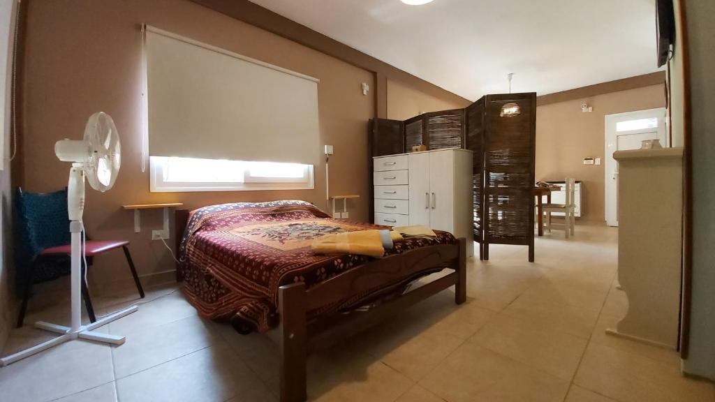 1 dormitorio con cama, escritorio y ventana en Depto Villa Gesell en Villa Gesell