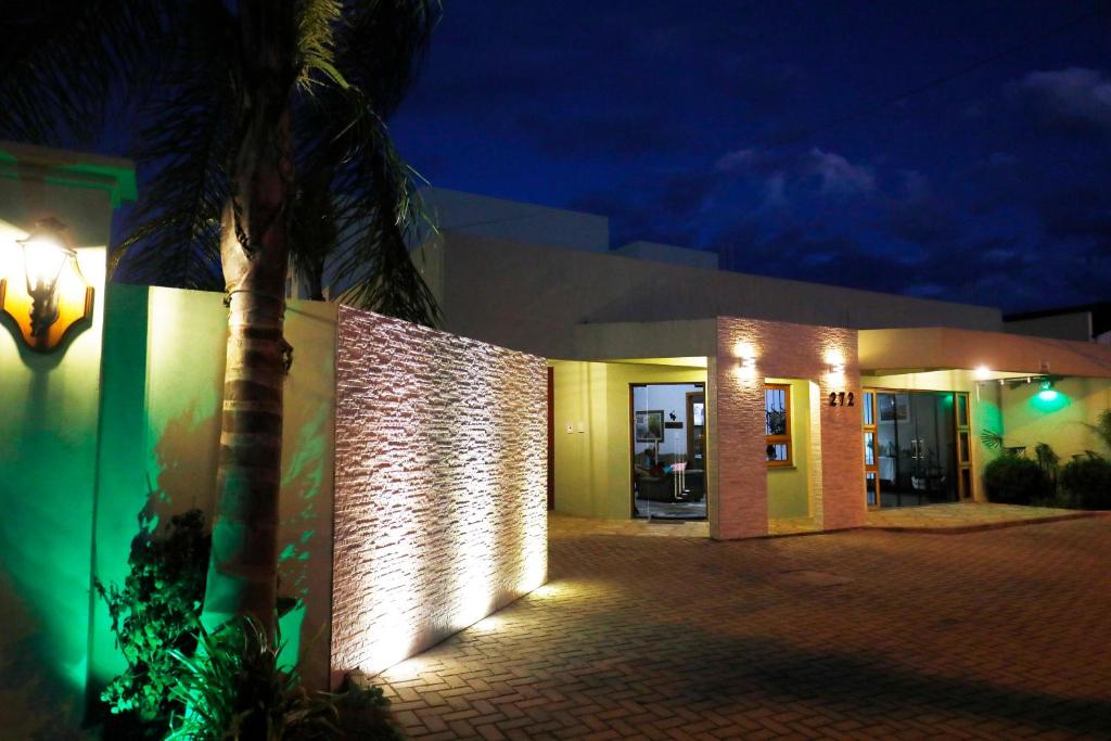 a building with a palm tree in front of it at night at Hotel Zona Sul in São Gabriel