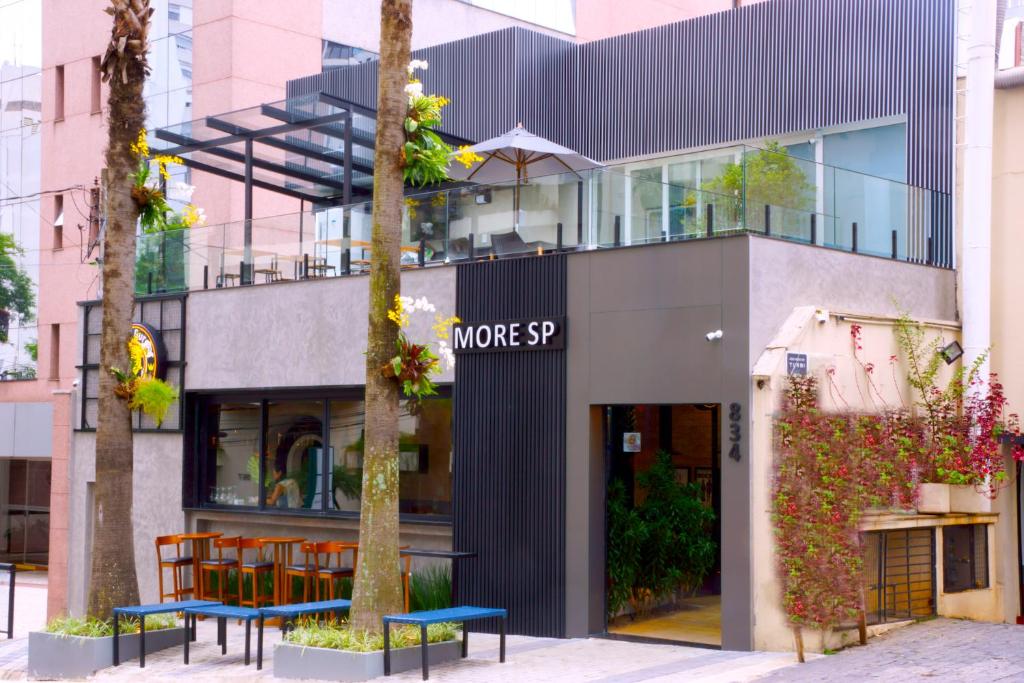 a building with two blue benches in front of it at Hostel More SP in Sao Paulo