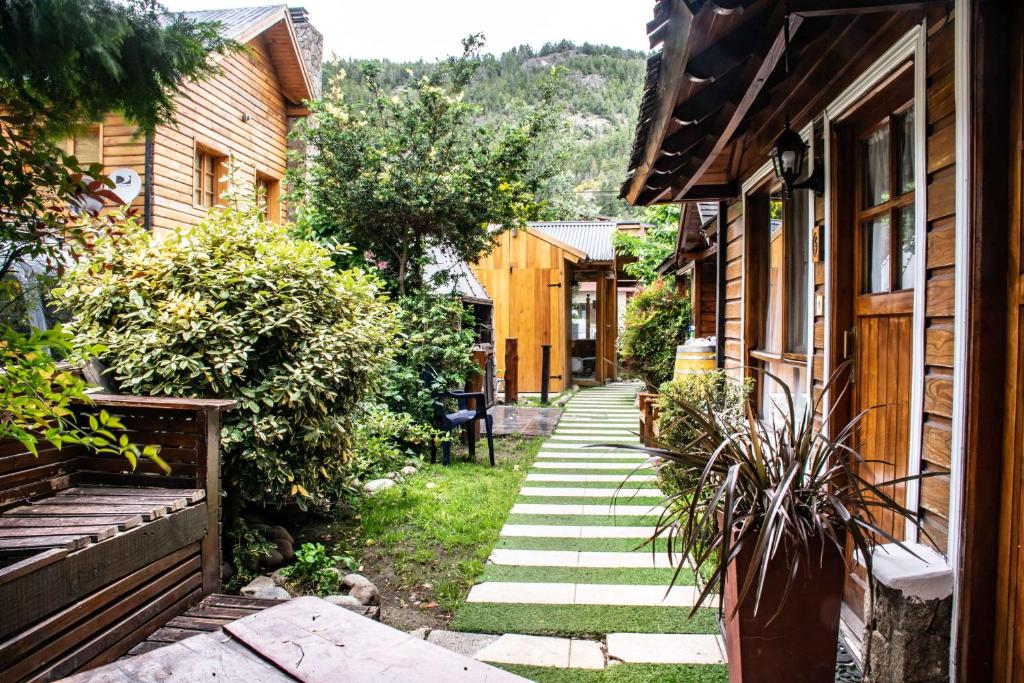 a walkway between two houses in a yard at Cabañas de la Patagonia in San Martín de los Andes
