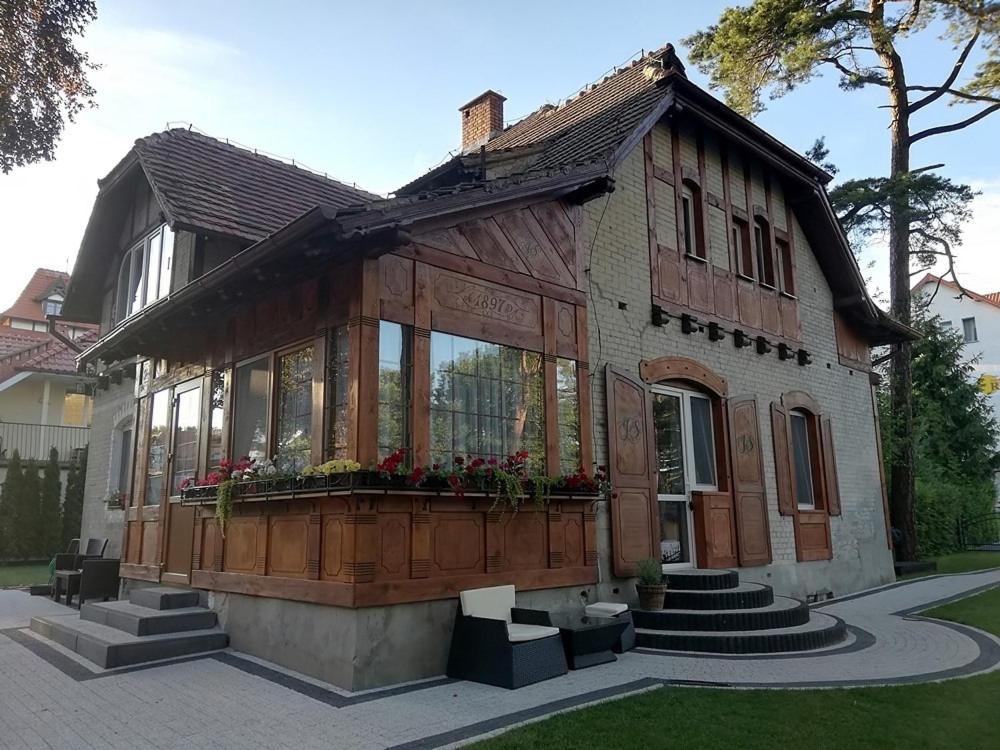 een huis met een veranda met bloemen erop bij Serce Krynicy in Krynica Morska