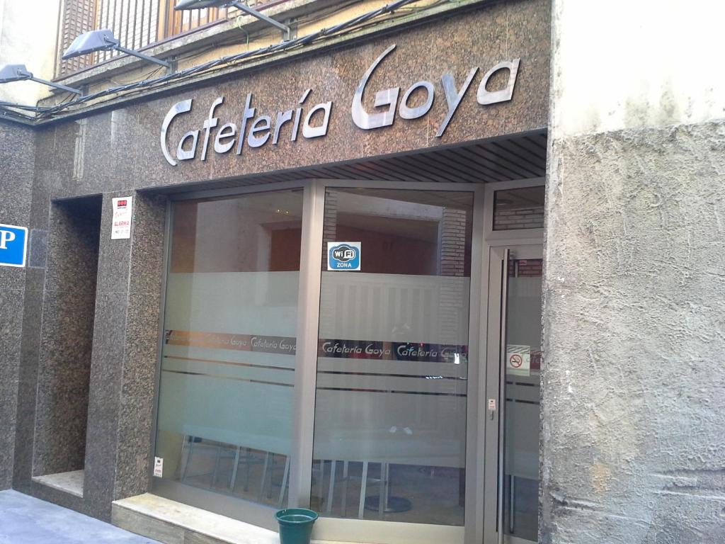 una tienda con un cartel en un lado de un edificio en Hostal Cafeteteria Goya, en Barbastro