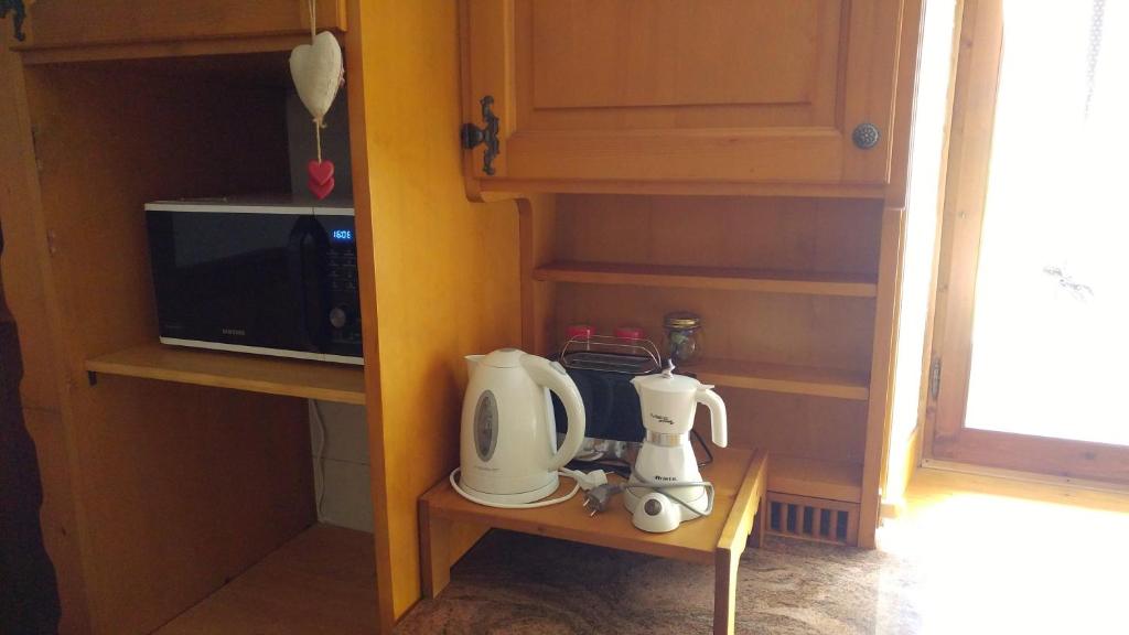 een keuken met een magnetron en een koffiezetapparaat op een plank bij Casa Vacanze Miramonti in Borca di Cadore