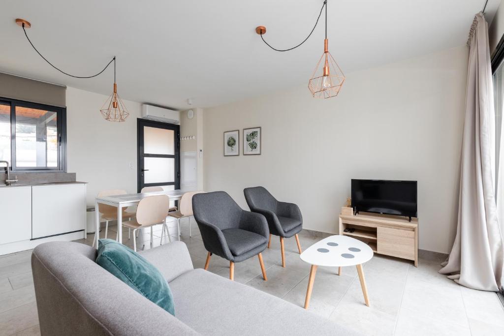 een woonkamer met een bank en stoelen en een tv bij Les Cyclistes - Apartment i in Malaucène