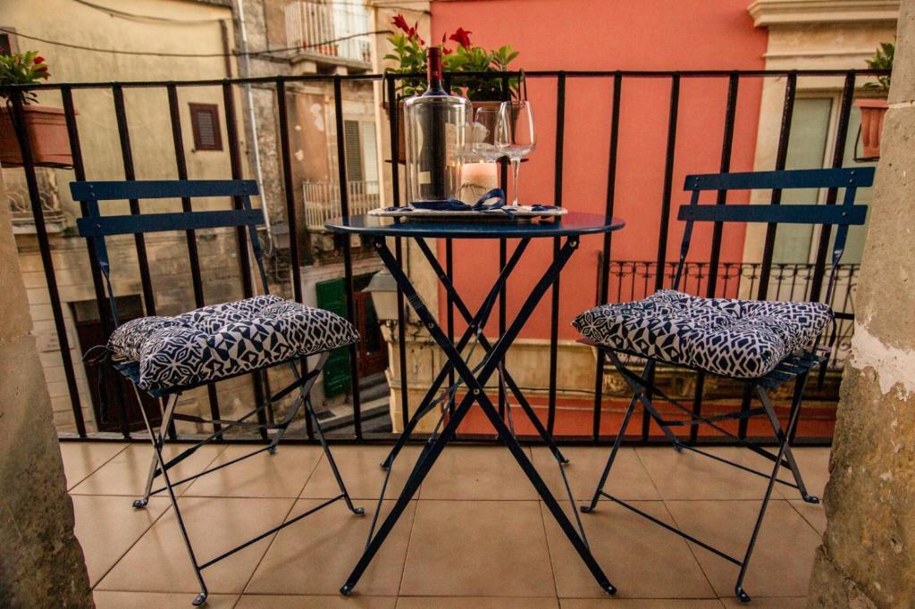 einen Tisch und zwei Stühle auf dem Balkon in der Unterkunft Casa Agorà in Palazzolo Acreide