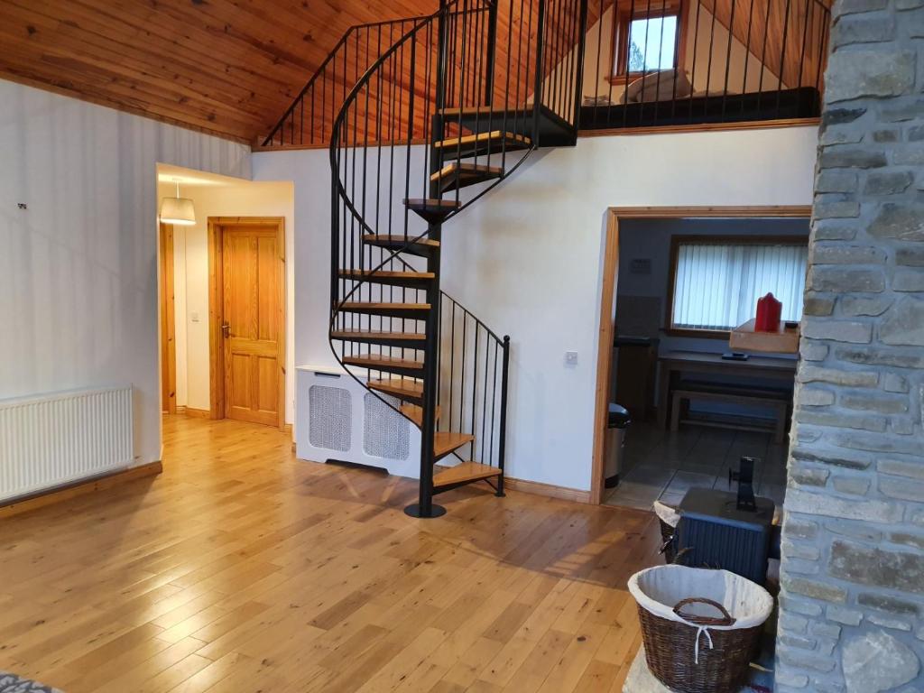 - un salon avec un escalier en colimaçon dans une maison dans l'établissement 19 Drumcoura Lake Resort, à Ballinamore