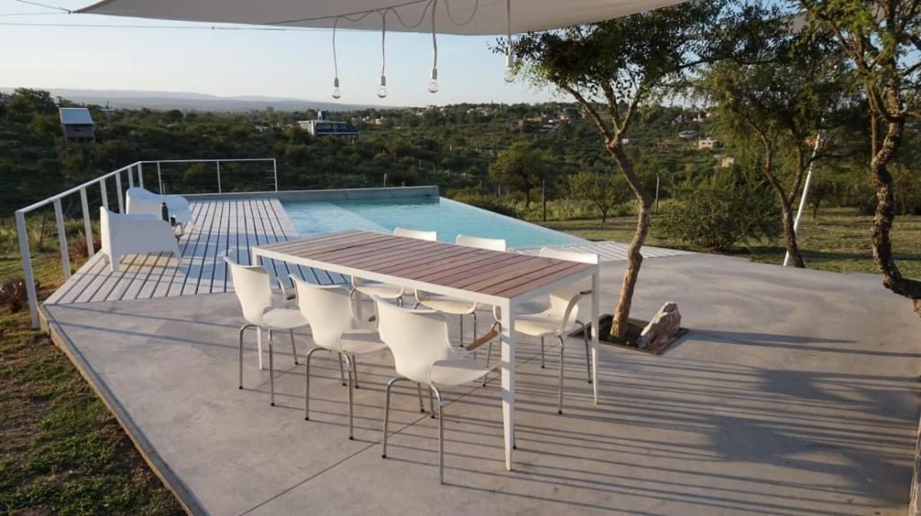 a table and chairs next to a swimming pool at Casa en las sierras in Villa Parque Siquiman