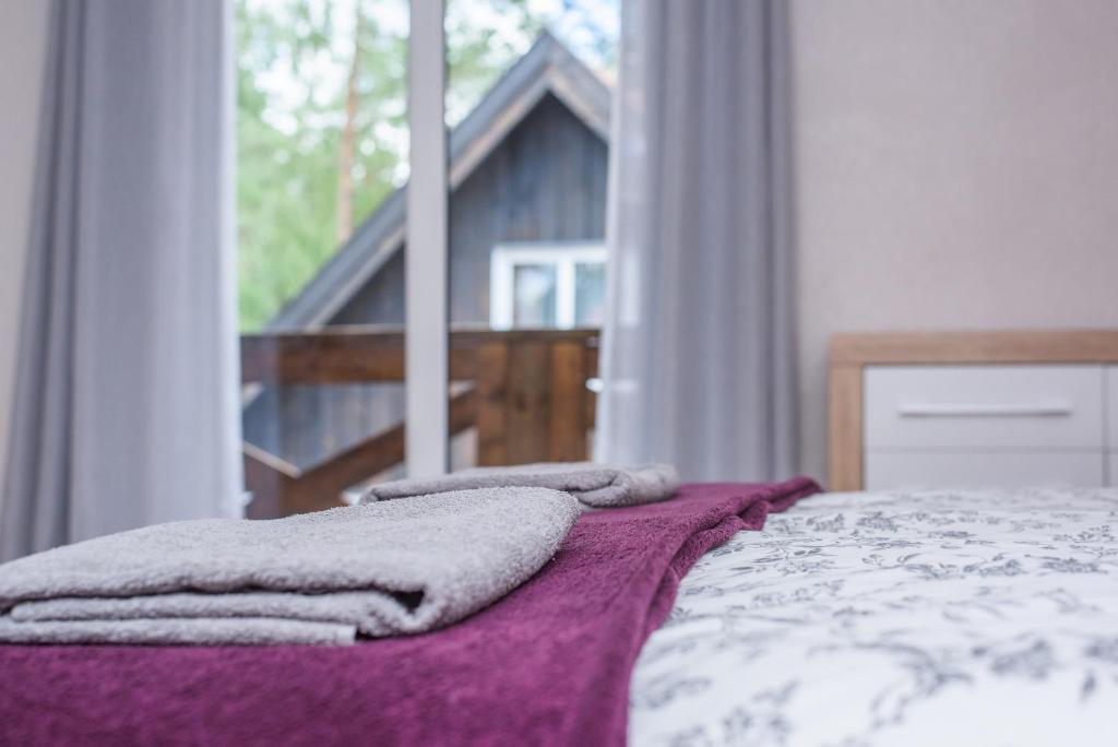 - une chambre avec un lit doté d'une couverture violette et d'une fenêtre dans l'établissement Dom Kaszubski nr 65, à Załakowo