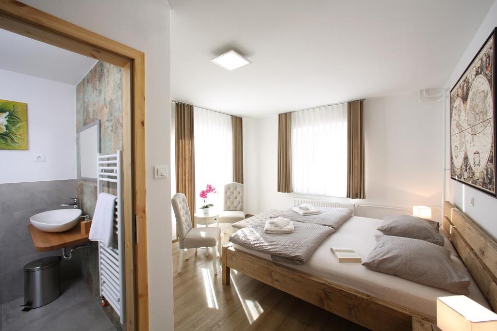 a bedroom with a large bed and a bathroom at Hiša Pr'Pristavc in Bohinj