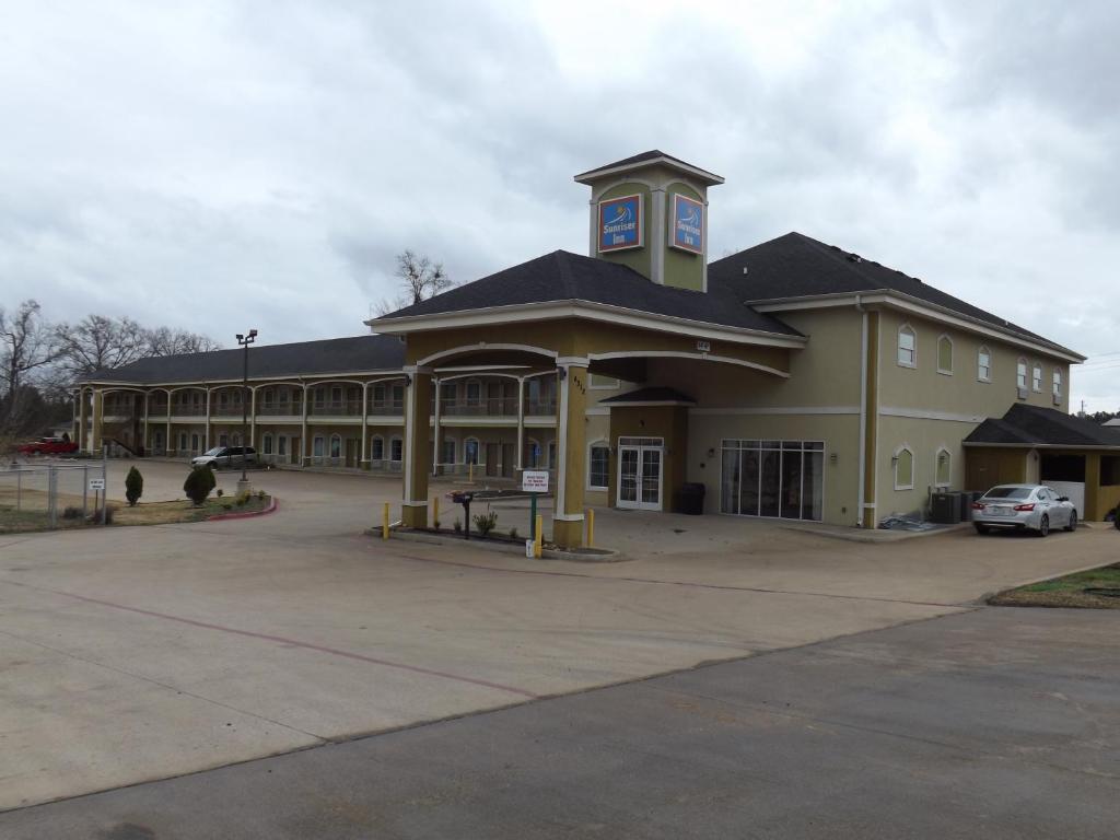 un grand bâtiment avec une tour d'horloge en haut dans l'établissement Sunriser Inn, à Kilgore