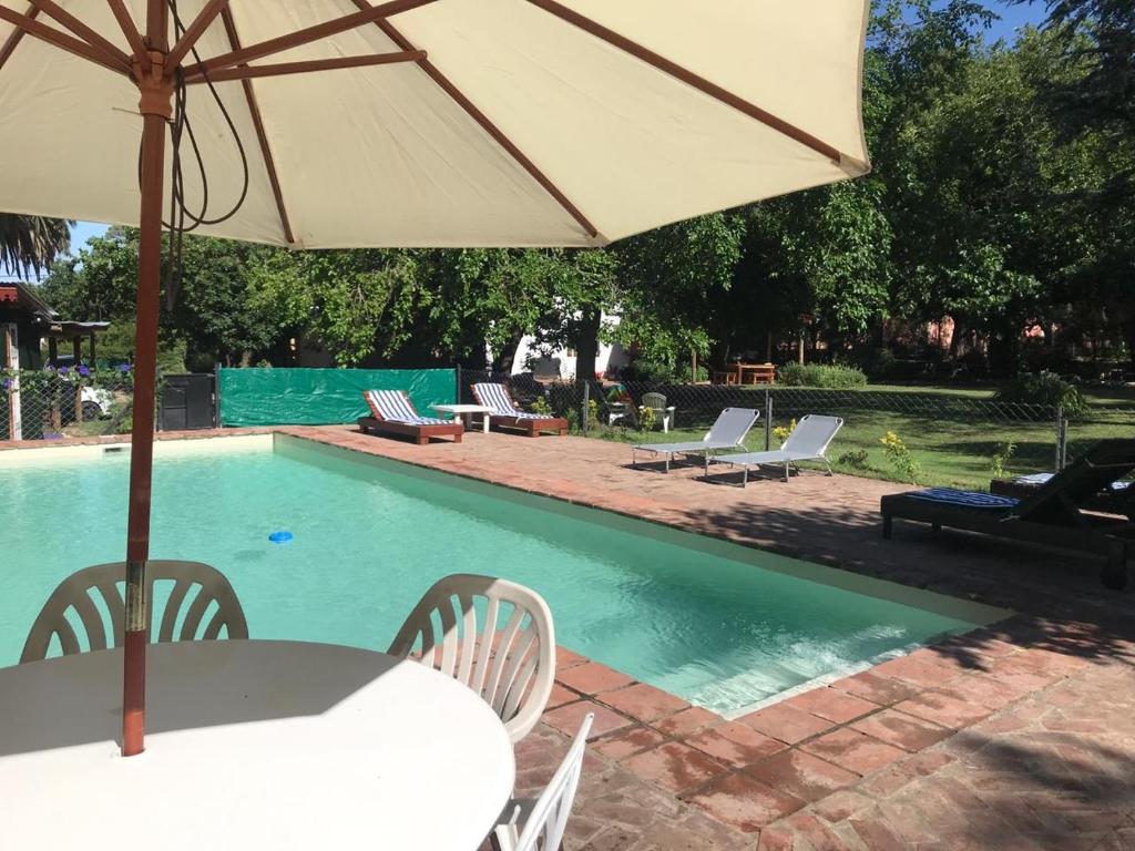 - une table avec un parasol à côté de la piscine dans l'établissement Posada El Cortijo, à San Javier