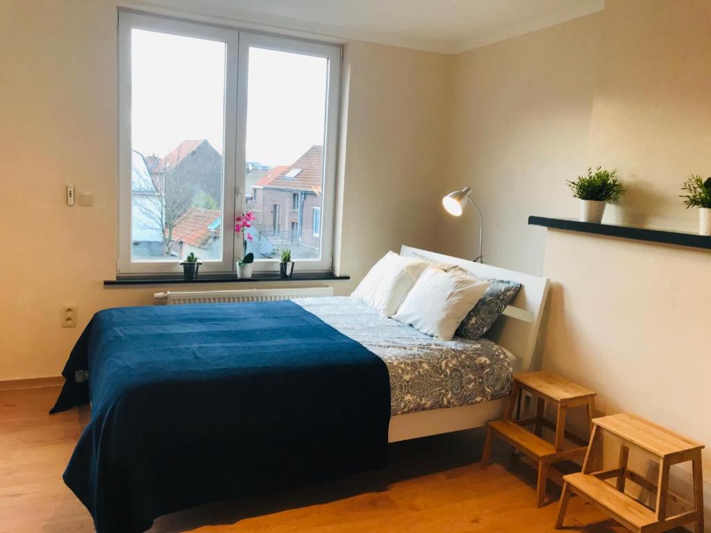 a bedroom with a bed with a blue comforter at Panda Bella in Zaventem