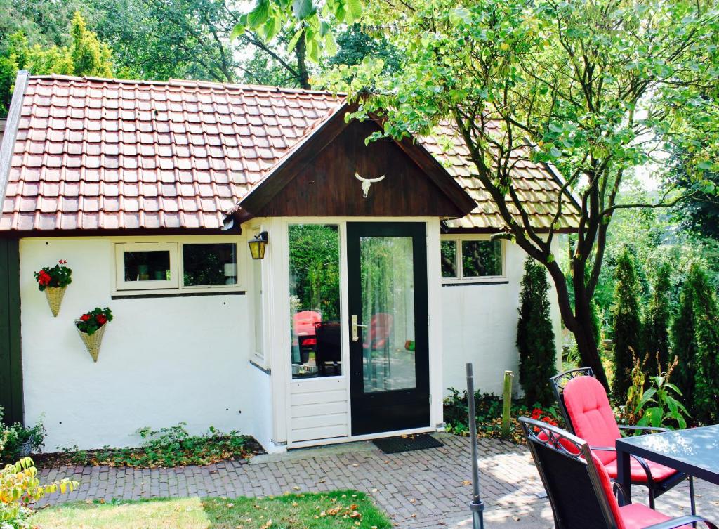 a small white shed with a door and a table at B&B Helene Hoeve in Venhorst