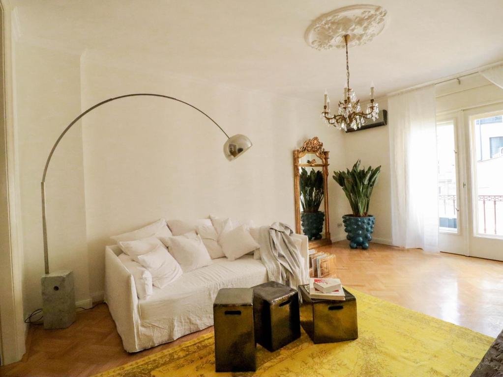 Hotel Hiraeth home, a living room with a white couch and a chandelier at Hiraeth home in Budapest