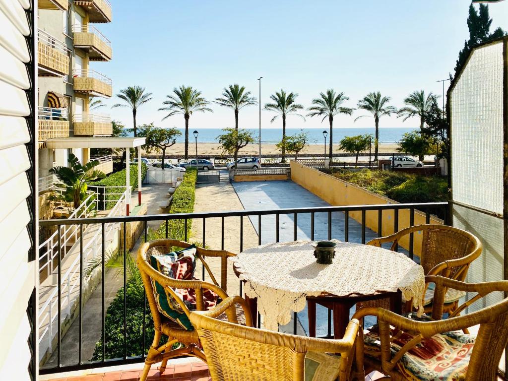 een balkon met een tafel en stoelen en uitzicht op het strand bij Vacaciones perfectas 2 in Segur de Calafell