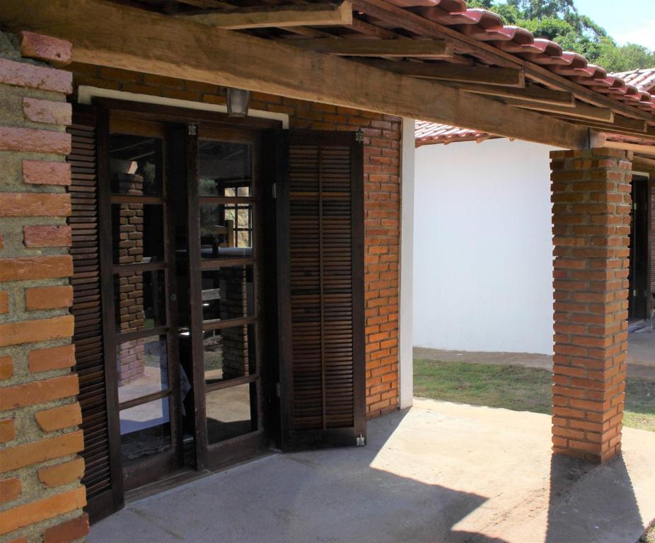 uma entrada para um edifício de tijolos com duas portas em Chalés Cachoeira Cafundó em Bueno Brandão