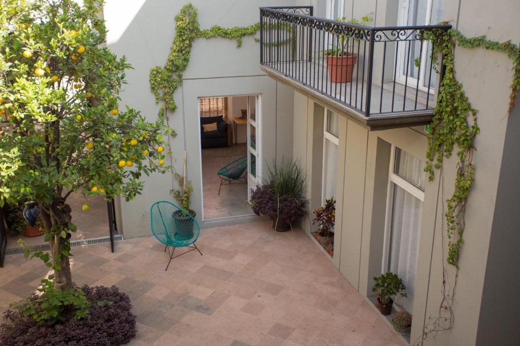 een overdekte binnenplaats met een balkon en planten bij Hotel Mamá Carlota in Querétaro