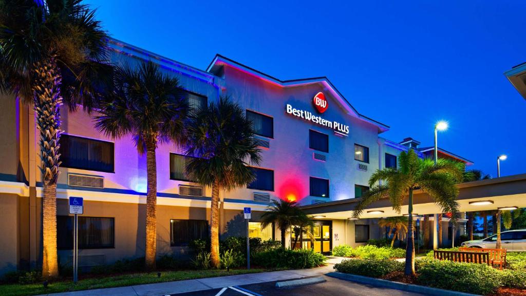 a hotel building with palm trees in front of it at Best Western Plus Sebastian Hotel & Suites in Sebastian