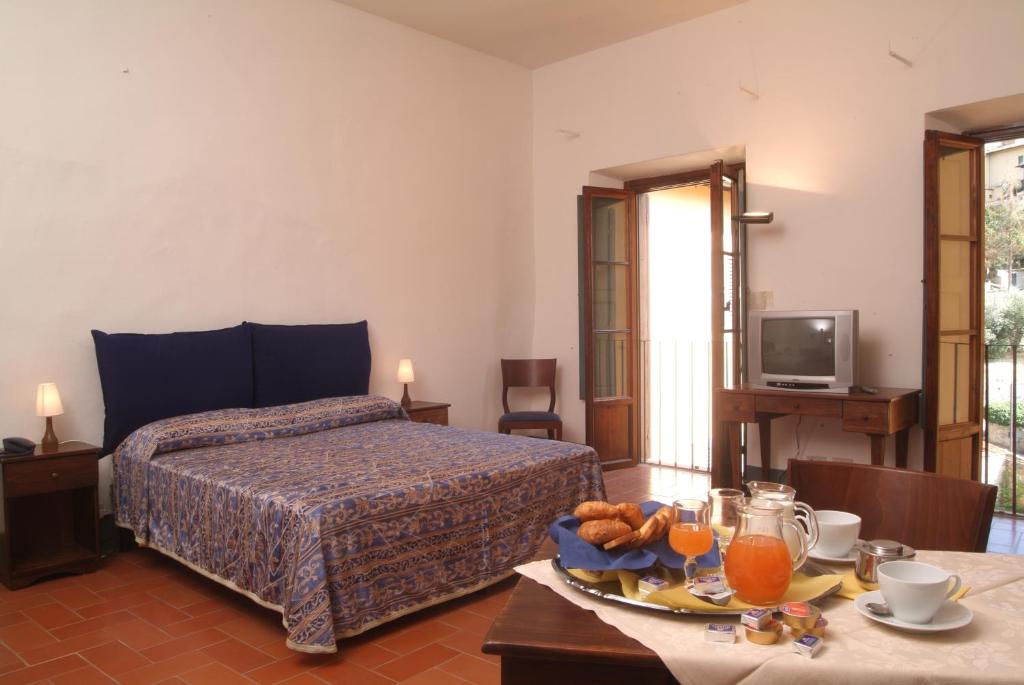 a bedroom with a bed and a table with a tray of food at Villa Morghen in Settignano