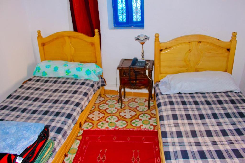 two beds sitting next to each other in a room at Dar Bleu Pearl in Chefchaouene