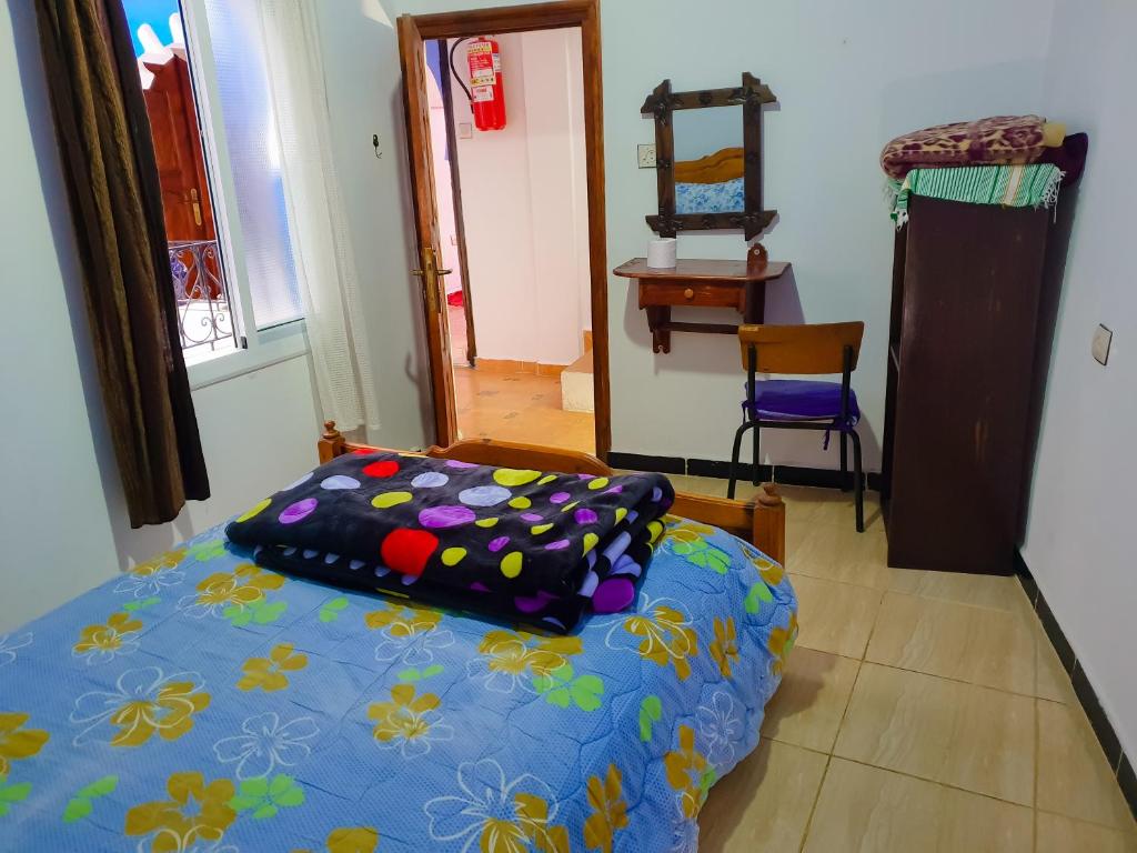 a bedroom with a bed and a table and a chair at Dar Bleu Pearl in Chefchaouene