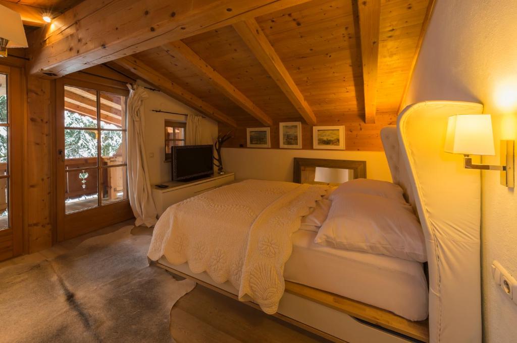 a bedroom with a bed and a television in a cabin at Das Kitz - deLuxe Chalet Valerie in Reith bei Kitzbühel