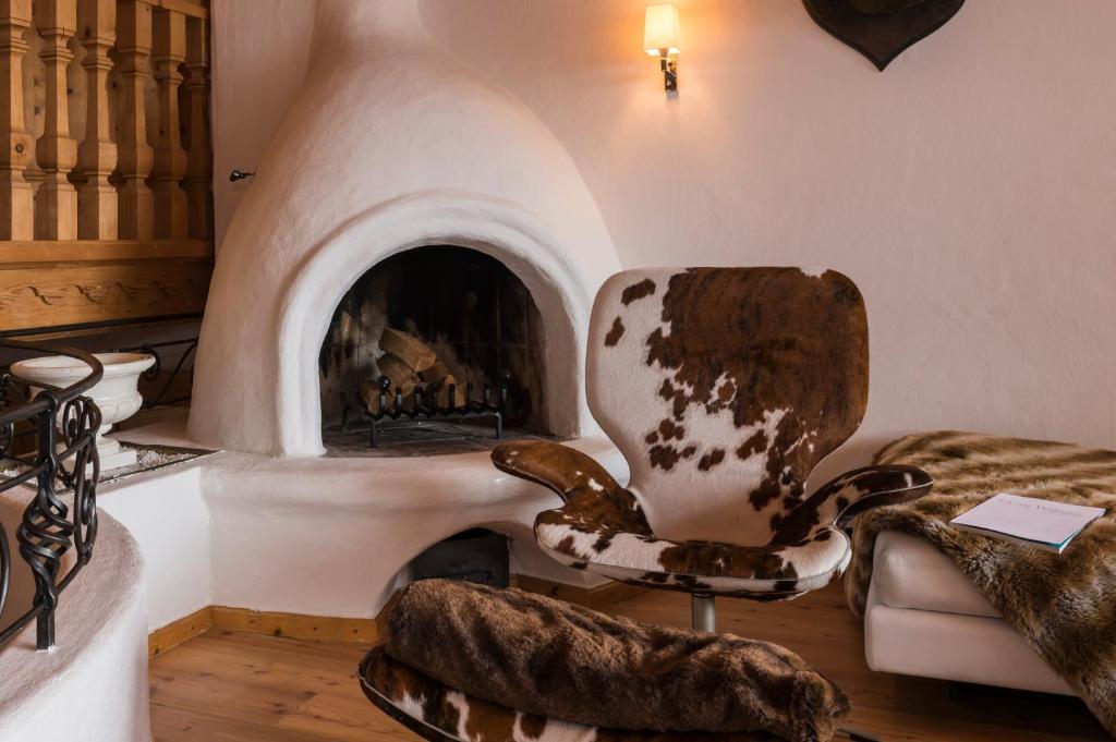a living room with a chair and a fireplace at Das Kitz - deLuxe Chalet Valerie in Reith bei Kitzbühel
